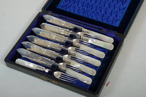 OBSTBESTECK WALKER & HALL sechs Gabeln und sechs Messer (Perlmutt und Silber), Sheffield, Anfang 20. Jahrhundert, Messerklingen ziseliert mit Weintrauben und Melonen, Gabelfläche ebenso, Messer 19,5 cm, Gabeln 16 cm lang, in Etui