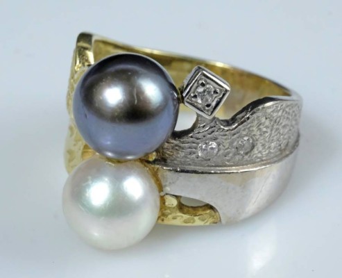 DESIGN-RING besetzt mit weißer und schwarzer Zuchtperle, bicolor, Fassung auf den Schultern vegetabil dekoriert, besetzt mit kleinen Diamanten, 585 Weiß-/Gelbgold, Goldschmiedestempel, 10,39g, Gr. 53