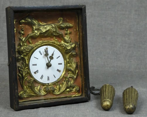 SCHWARZWALD-WANDUHR mit Relief in Messingblech, oben galoppierendes Pferd, um die Uhr herum vegetabil dekoriert, Emailleuhr mit römischen Ziffern und Goldzeiger, Schwarzwald um 1860/1870, mit Gewichten, Maße 24x20x14cm