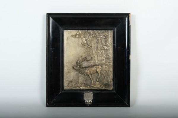 Hirsch-Relief, Abbildung eines Hirsches im Wald, Körper des Hirschs hervorstehend, bezeichnet: 