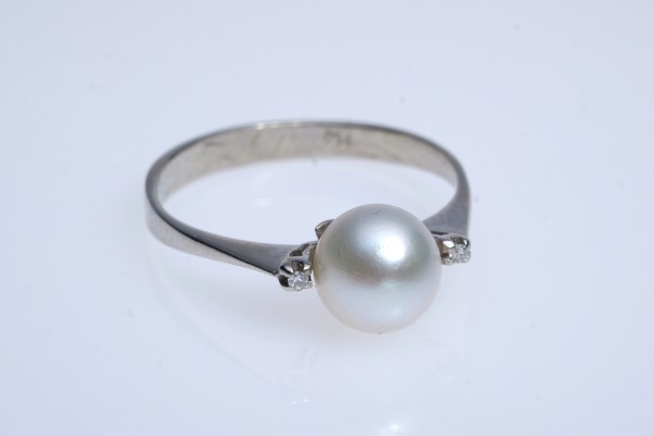 Ring mit mittig gefasster Zuchtperle (Durchmesser 7 mm), flankiert von zwei kleinen Brillanten.