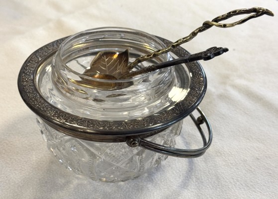 Glasschale mit Deckel und zwei Löffeln.