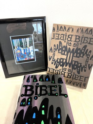 Hundertwasserbibel im Schuber und gerahmte Hundertwasser Postkarte. Bibel mit zahlreichen Illustrationen, mit samtartigen Segmenten geschmückter Leineneinband. Schuber ebenfalls passend gestaltet.