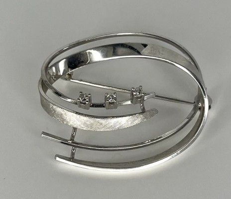 Brosche in moderner Form, besetzt mit drei kleinen Brillanten, Weißgold 585 (punziert).