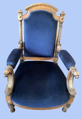 Historismus Sessel, Massivholzgestell Nussbaum, neue Polsterung in Königsblau, um 1880. Reich geschnitzt und gedrechselt. Die Köpfe der Armlehnen sind als Löwenköpfe ausgeführt, was Stärke und Kraft symbolisiert. An einer Armlehne fehlt ein kleines Holzelement, ansonsten tadelloser Zustand entsprechend dem Alter.