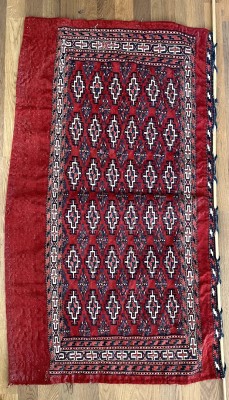Turkmenische Eseldecke, handgeknüpft, zweite Hälfte 20 Jahrhundert. Rotgrundig, mit Wandhängung aus Bambusrohr. Auf der Decke sind stilisierte Diamanten dargestellt.