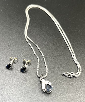 Saphirset, Kette und Ohrstecker, mit Brillanten, 585 Weißgold. Feine Weißgold Kette, an der ein Tropfenförmiger Saphir hängt. Dieser von fünf Brillanten umrandet. Die Ohrstecker ebenso mit tropfenförmigen Saphir und einzelnem Brillanten darüber.
