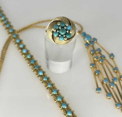 Schmuck-Konvolut, drei-teilig, mit Türkissteinen, 585/750 Gelbgold und vergoldet. Bestehend aus einem gegliederten Armband mit einzelnen Türkisen besetzt, 750 Gelbgold, punziert. Ein Ring in Knotenform, auch mit Türkisen besetzt, 585 Gelbgold, Größe 52. Eine Kette mit vergoldetem Anhänger, dieser mit blauen Steinen besetzt, Fäden-artig, Länge 26 cm.