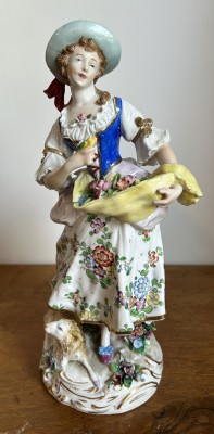 Volkstedt-Rudolstadt Porzellanfigur, Frau mit Blumen und Lamm, 20. Jahrhundert. Darstellung einer Frau mit Blumen und Lamm, reich bemalt und vergoldet.