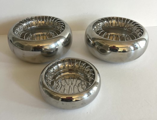 Alessi, Aschenbecher, drei Stück, Edelstahl, 20./21. Jahrhundert. Der Drahteinsatz, kann herausgenommen werden und so sind diese auch als Schalen zu verwenden.