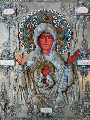 Gottesmutter vom Zeichen, 1797, russische Ikone. Die Ikone zeigt die Gottesmutter vom Zeichen. Die Muttergottes ist frontal dargestellt, mit erhobenen Händen in Gebetshaltung. Auf ihrer Brust, im Medaillon, befindet sich das Christuskind (Emmanuel) als Halbfigur mit segnender Geste. Die Inschrift oben links und rechts (