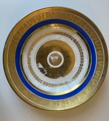 Porzellanteller mit Goldstaffage und breitem blau-goldenem Rand.