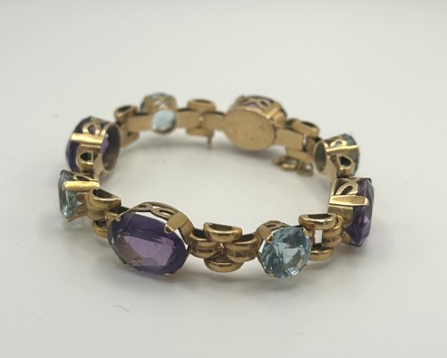 Goldarmband, mit grünen und lila Amethysten gefasst, 750 Gelbgold. Fein gearbeitetes Armband, besetzt mit abwechselnd gefassten, facettierten Amethysten in grün und violett. Durch offene Seitenpartien der Fassungen, wird der Lichteinfall und somit das Leuchten der Steine betont. Die Glieder sind beweglich gearbeitet. Steckverschluss mit Sicherheitsacht.
