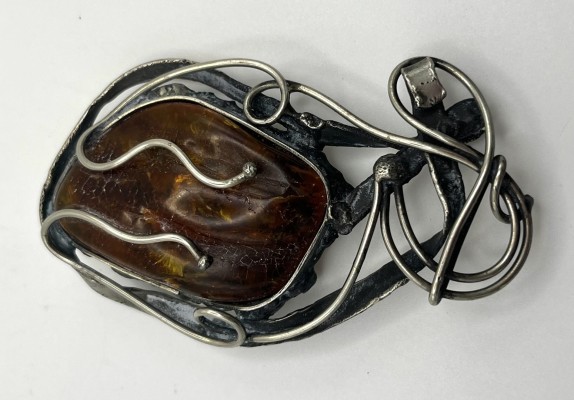 Bernsteinbrosche, 925 Sterlingsilber. Modernes Design, fischartige Form. Großer Bernstein verschlungen in Metalldrähten.