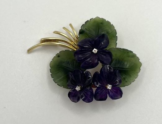 Brosche, feine Blütenform, 585 Gelbgold, drei Brillanten. Drei grüne Blätter umranden die violetten Blüten, in denen die Brillanten eingelassen sind.