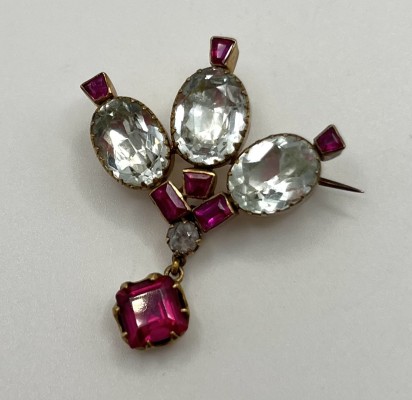 Brosche, mit verschiedenen Schmucksteinen, vergoldet. Aufgefächertes Design mit drei mittig angelegten weißen Steinen, außen verschiedene rote Steine.