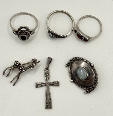 Silberkonvolut, 835/925 Silber, bestehend aus drei Ringen, zwei Broschen und einem Anhänger. 835 Silber: Ein Ring, Größe 52, eine Brosche in Rehform und einem Anhänger in Kreuzform. 5,53g.