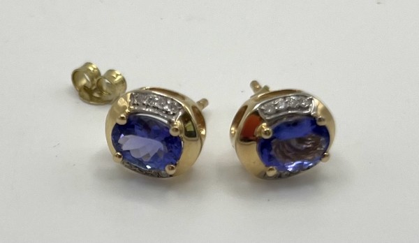 Paar Ohrstecker mit je einem Tansanit AAA, 585 Gelbgold, Tansanit oval facettiert, um 2,4 ct, umgeben von 16 Brillanten F/C P1 Wesselton, 0,12 ct TW. Manufaktur Harry Ivens, Gesamtgewicht 3,77 g.