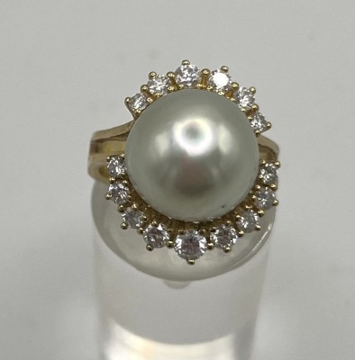 Perlenring, 750 Gelbgold, mit 15 Brillanten, Größe 53. Ein sehr edler Ring, bei dem die Fassung der Perle in aufgefächerter Form ebenfalls 15 Brillanten enthält. Halb-Perldurchmesser 12 mm,Gesamt 10,4g.