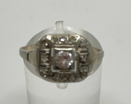 Brillantring, 585 Weißgold, größter Brillant um 0,1ct, Größe 57. Quadratischer Ringkopf mit mittig gefasstem Brillant, der von weiteren kleineren Brillanten umrandet wird.
