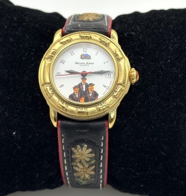 Michel Jordi Damenarmbanduhr, Geneve, Quarzwerk. Datumsanzeige bei drei Uhr, weißes Ziffernblatt mit der Darstellung dreier Personen auf sechs Uhr. Mit Edelweißapplikationen auf dem original Lederarmband, Funktion nicht geprüft.